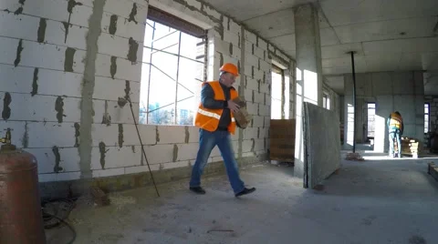 Builder in helmet working in a new house under construction. 库存影片 58297992