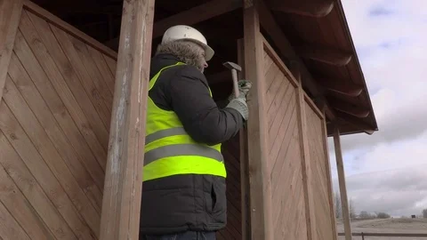 Builder hitting nail with hammer Stock Footage