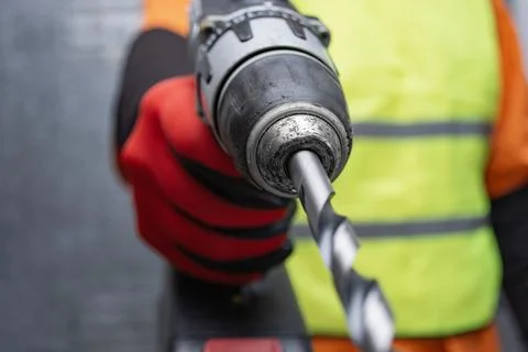 Builder holding a cordless power drill machine. Concept of precision engineer Stock Photos