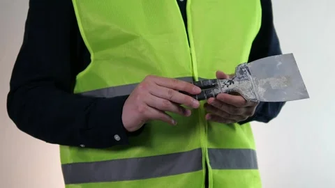 A builder holds a dirty construction spatula in his hands. A tool for work that Stock Footage 313046317