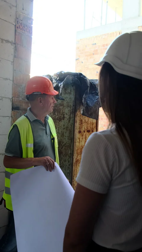 Builder holds floor plan explaining processes to inspectors Stock Footage 317622627