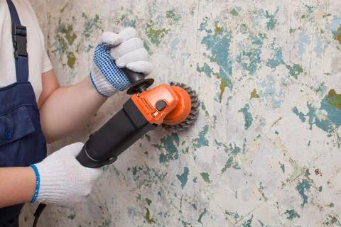 The builder holds in hands Angle grinder. Repair work, interior decoration of Stock Photos
