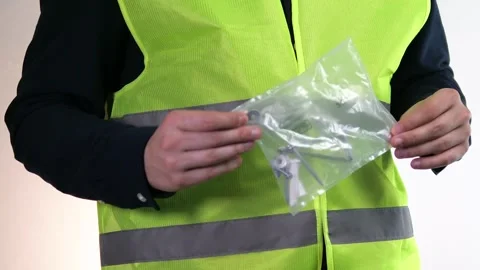 The builder holds screws, nails and other building materials for construction Stock Footage 313046329