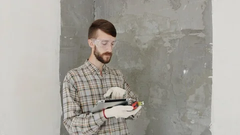 Builder in house under construction using tablet Stock Footage 92316842