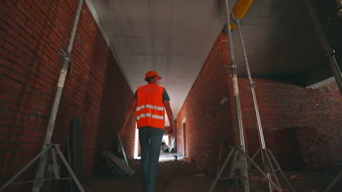 Builder inside the house. The builder goes inside the building under 库存影片 202251633