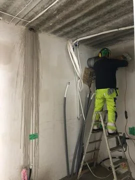 A builder installer carries out work in a building under construction Foto stock