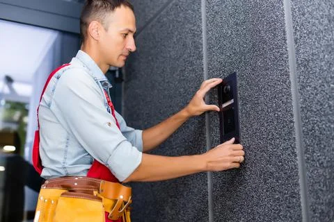 Builder installing an intercom. renovation in a renovated building Fotos de archivo