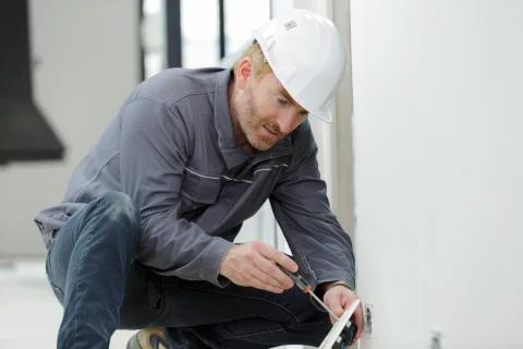 Builder installing a socket indoors Stock Photos