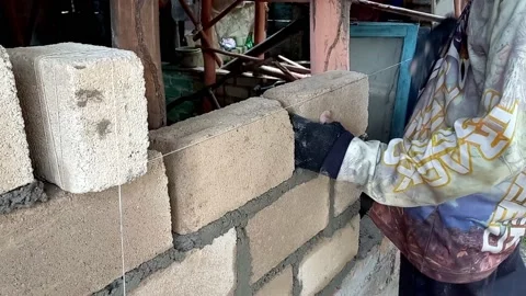 A Builder Installing, Stacking And Tidying Bricks Using A Waterpass Stock Footage 236353686