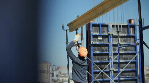 Builder installing wooden beam on high-rise construction site Video stock 318411998