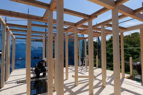 Builder Installing Wooden Structural Beams at Residential Construction Site Foto stock