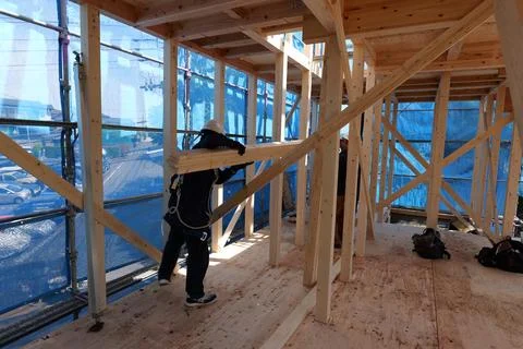 Builder Installing Wooden Structural Beams at Residential Construction Site Foto stock