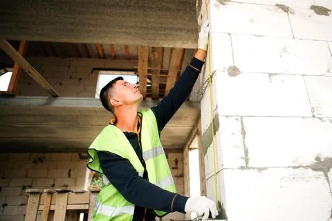 Builder installs structure fasteners, screws walls together, site mounting,.. Stock Photos