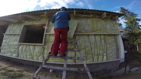 Builder insulating farm house frame, 4K Stock Footage 68712765