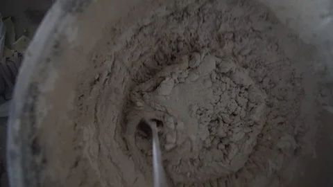 Builder interferes with cement in a bucket Stock Footage 129108224