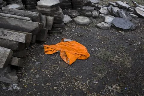 Builder jacket  orange colored  on ground. Road worker uniform. Stock Photos
