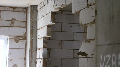 Builder knocking breeze blocks out of a wall with hammer Stock Footage 112609355