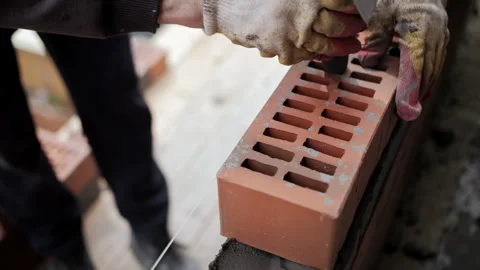 Builder laying brick wall with trowel and mortar at construction site Stock Footage 315957826