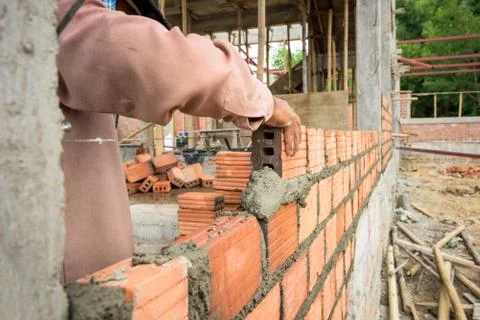 Builder laying bricks in site. Fotos Stock