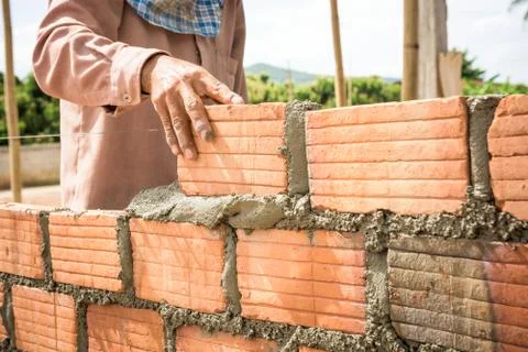 Builder laying bricks in site. Stock Photos