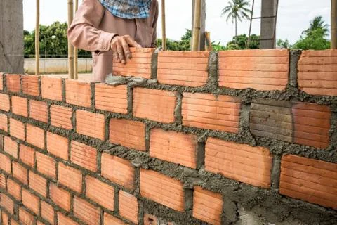 Builder laying bricks in site. Fotos Stock