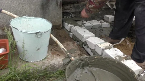 The Builder is laying bricks on the solution Stockbeeldmateriaal 136640459