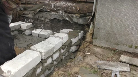 The Builder is laying bricks on the solution Vídeos de archivo 136640700