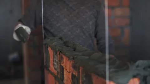 Builder laying red brick wall. Spatula for applying cement mortar Stock Footage 279019626