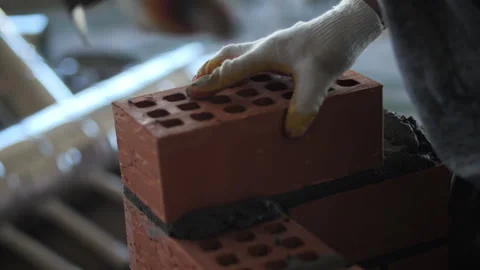 Builder laying red bricks with trowel and mortar during wall construction work Stock Footage 318780146