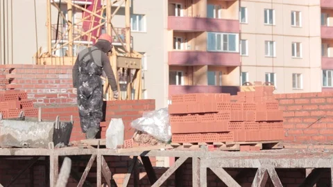 Builder lays a brick, view from the back Stock Footage 117661115