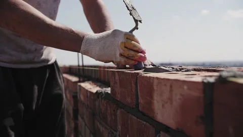 Builder lays brick wall, hands close-up Stock Footage 217977544