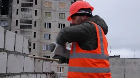 A builder lays bricks on cement, builds a brick wall. Stock Footage 325567136