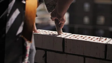 A builder lays bricks at a construction site Stock Footage 244544550
