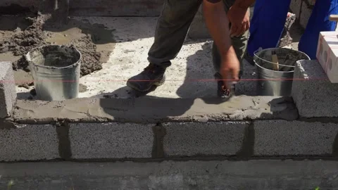 A builder lays concrete blocks on a construction site Stock Footage 314675150