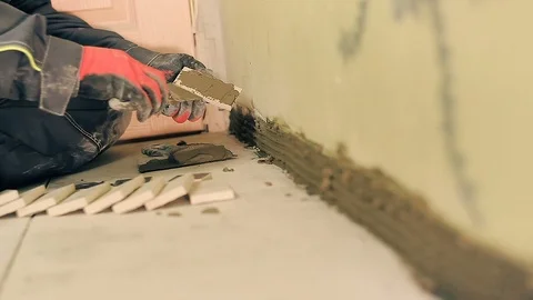 Builder lays a small tile Stock Footage 88980190