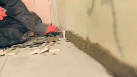 Builder lays a small tile Stock-Footage 90982603