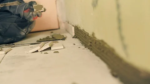 Builder lays a small tile Stock Footage 90983493