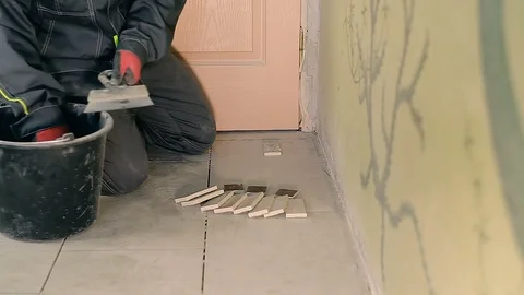 Builder lays a small tile Stockbeeldmateriaal 94428664