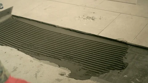 The Builder lays the tiles on the floor Stock Footage 88979775