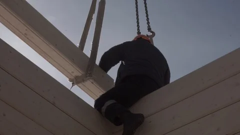 The builder lays the timber on the wall under construction. Stock Footage 106627955