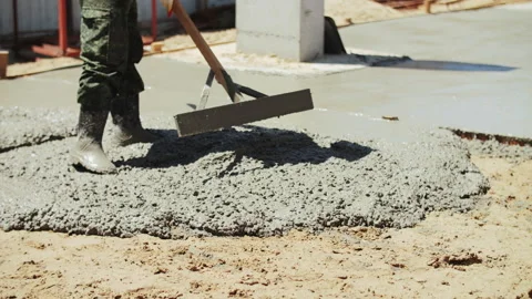 Builder leveling liquid concrete at the construction site Stock Footage 287688273