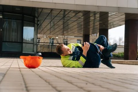 The builder lies down after a leg injury. Industrial accident concept. a youn Stock Photos
