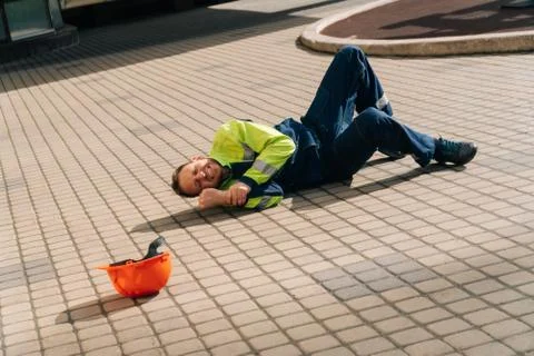 The builder lies down after a leg injury. Industrial accident concept. a youn Stock Photos