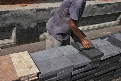 A builder is lifting natural stone Stock Photos