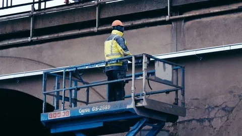 Builder is lifting on a scissor lift Stock Footage