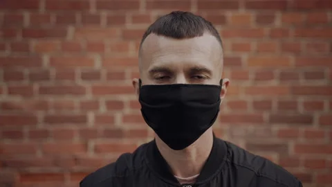 Builder looks into the camera, removes the protective mask, spits to the side Stock Footage 163919508