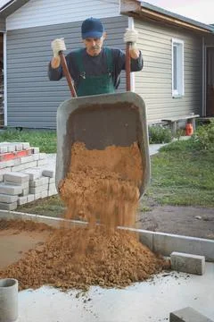 Builder makes a backfill for the pavement Stock Photos