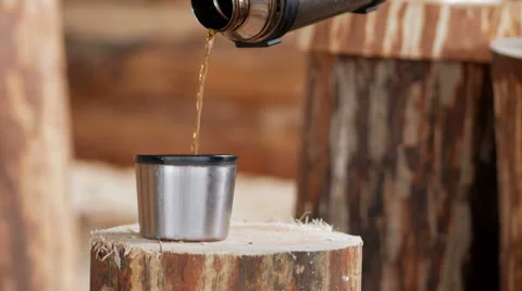 Builder makes coffee break from a thermos. Wooden buildings in the background Stock Footage 69070053
