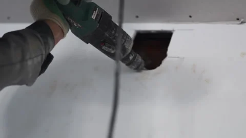 Builder makes hole with electric tool in repaired room Stock Footage 273401802