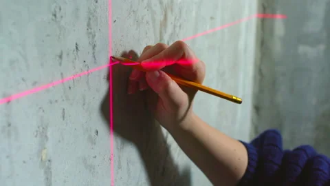 Builder makes markings using a laser level. Stock Footage 169447750